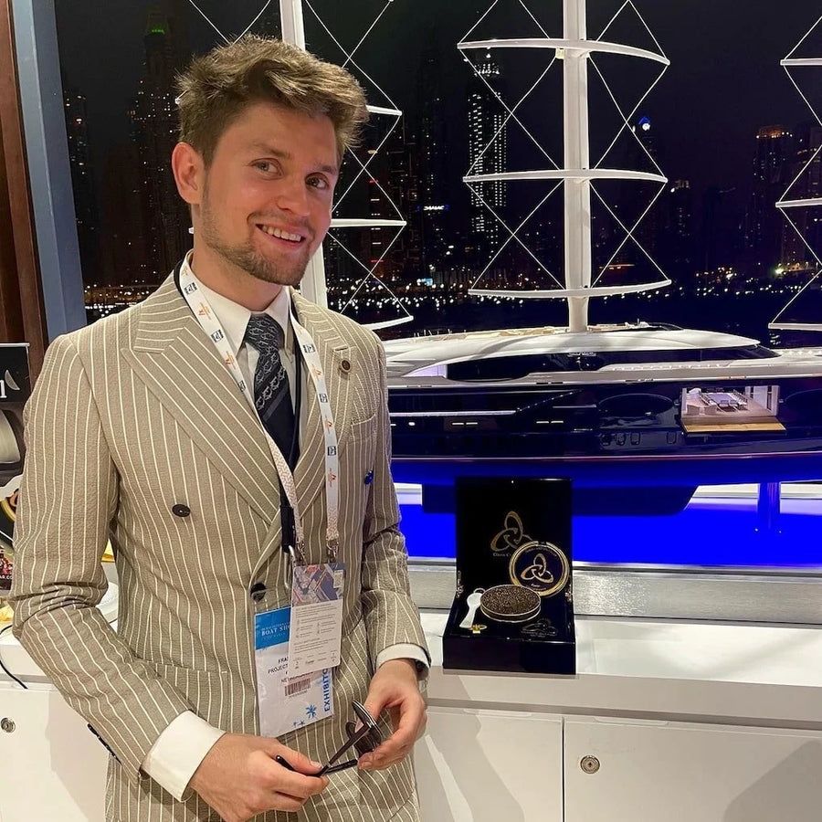 Lars Langhein devant une maquette de superyacht et un coffret de caviar